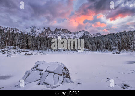 Tramonto sul lago di Carezza con neve sullo sfondo il gruppo del Latemar, Ega, Dolomiti, Trentino Alto Adige Italia Foto Stock