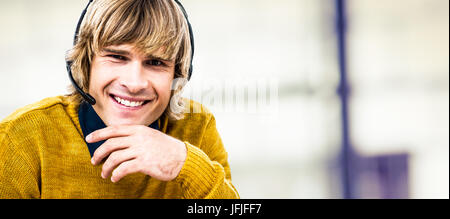 Immagine composita di sorridere hipster imprenditore utilizza una cuffia Foto Stock