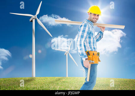 Immagine composita del lavoratore sorridente che trasportano tavole di legno Foto Stock