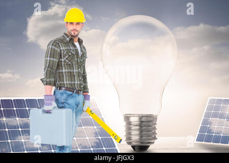 Immagine composita del lavoratore manuale con livello di spirito e la casella degli strumenti Foto Stock