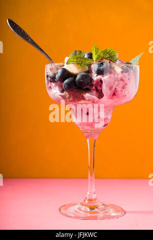Semifreddo al vetro ciotola da dessert sul giallo sfondo sfocato verticale Foto Stock