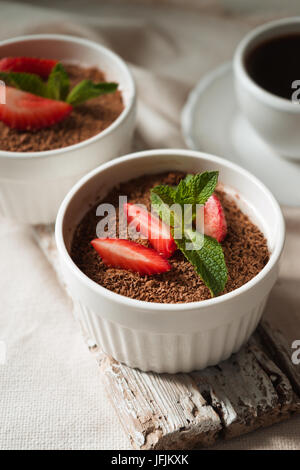 Tiramisù alla fragola e menta in ramekins sul tavolo bianco in verticale Foto Stock