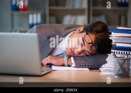 Uomo d'affari che soggiornano in ufficio per lunghe ore Foto Stock