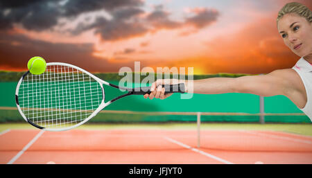 Atleta giocando a tennis con un racket contro generati digitalmente immagine del campo da tennis Foto Stock