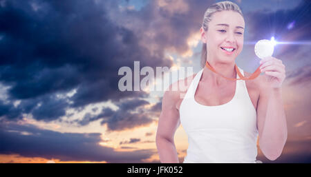 Immagine composita di felice atleta femminile medaglia di contenimento Foto Stock