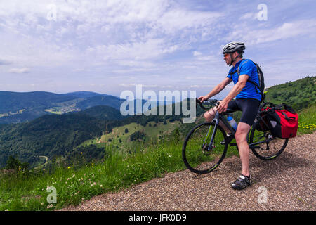 Uomo seduto sulla bicicletta guardando le montagne Foto Stock