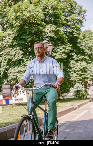 Imprenditore Bicicletta Equitazione per lavorare su strada urbana in mattina. Lo stile di vita, i trasporti, la comunicazione e il concetto di popolo, Foto Stock