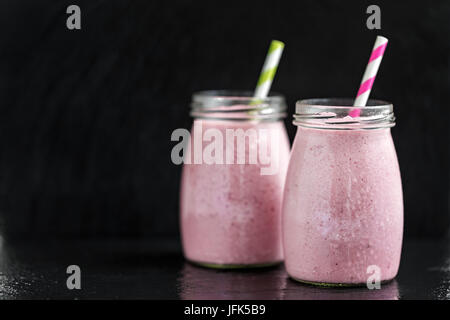 Due bicchieri con berry pink frullati con ribes e mirtillo rosso, il fuoco selettivo. Foto Stock