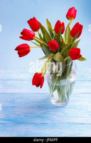 Tulipani rossi sul tavolo di legno Foto Stock