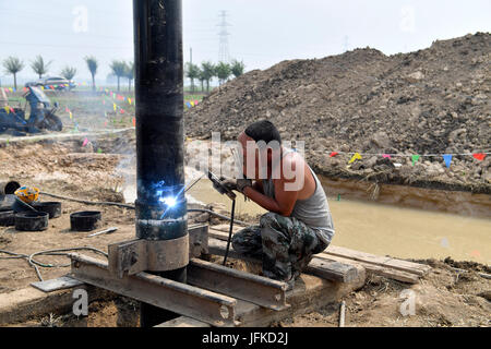 Anxin cinese nella provincia di Hebei. 1 Luglio, 2017. Un esperto di saldatura di un tubo a Dawang Township della contea di Anxin, nel nord della Cina di nella provincia di Hebei, 1 luglio 2017. Il servizio geologico ha avviato in Xiongan nuova area, una nuova zona economica vicino a Pechino. Credito: Jin Liangkuai/Xinhua/Alamy Live News Foto Stock