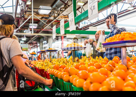 Montreal, Canada - 28 Maggio 2017: uomo vendere produzione da frutta stand con campione di fette a Jean-Talon farmers market con display Foto Stock