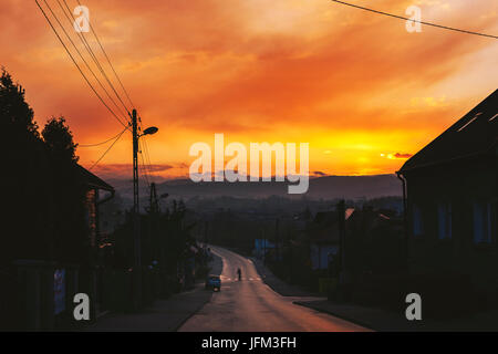 Attraversamento pedonale long street con il tramonto del sole sulle montagne sullo sfondo Foto Stock