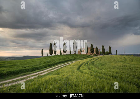 San Quirico d'Orcia, Toscana, Italia, una casa colonica al tramonto, durante un giorno di tempesta, Foto Stock