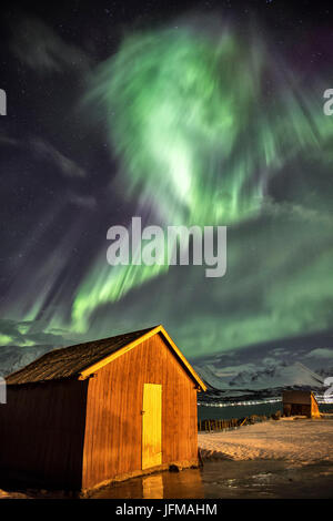 Northern Lights illumina la cabina in legno a Lenangsoyra Alpi Lyngen Tromsø Lapponia Norvegia Europa Foto Stock