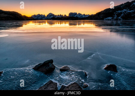 L'Italia, Trentino Alto Adige, nel Parco Naturale Adamello Brenta, Val Nambrone, il gruppo delle Dolomiti di Brenta in inverno sono riflessi nel ghiaccio del Lago Nero all'alba, Foto Stock