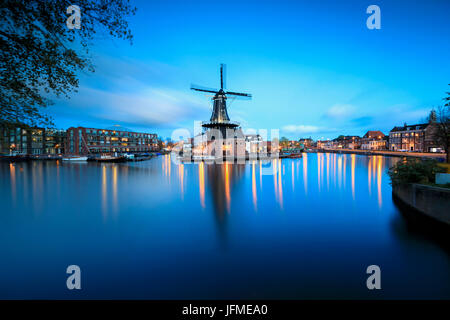 Le luci del tramonto sul mulino a vento De Adriaan riflessa nel fiume Spaarne Haarlem Olanda settentrionale dei Paesi Bassi in Europa Foto Stock