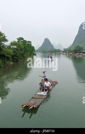 Cina, provincia di Guangxi, Guilin, regione carsica del paesaggio di montagna e fiume Yulong intorno a Yangshuo, turisti cinesi su una zattera Foto Stock