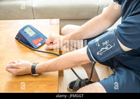 La misurazione della pressione sanguigna, con un sistema automatico di braccio superiore della pressione sanguigna misuratore, Foto Stock