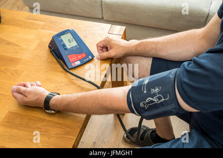 La misurazione della pressione sanguigna, con un sistema automatico di braccio superiore della pressione sanguigna misuratore, Foto Stock
