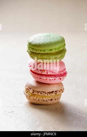 Tre i cookies colorati macaron in pila su sfondo chiaro Foto Stock