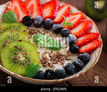 Gustosa e salutare porridge di fiocchi d'avena con frutta, bacche e semi di lino. Una sana prima colazione. Cibo per il fitness. Una corretta alimentazione. Foto Stock