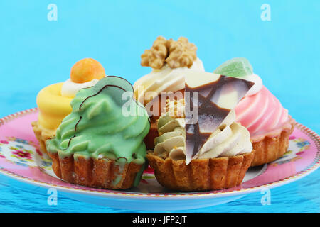 Selezione di freschi e deliziosi torte di panna su vivid sfondo blu Foto Stock