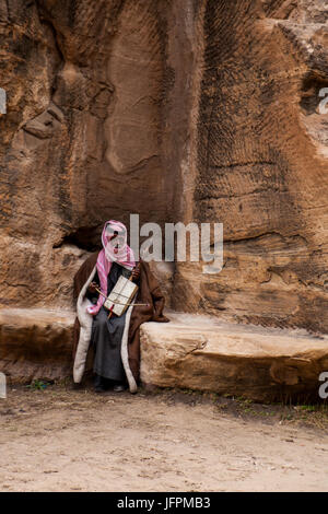 Uomo Beduin - Little Petra - un uomo vecchio a giocare il suo strumento nel deserto giordano vicino a Petra (Wadi Rum area) medicazione tipici abiti tradizionali. Foto Stock