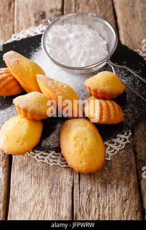 I cookie di francese in forma di un guscio - Madeleine close-up su una vecchia tavola verticale. Foto Stock