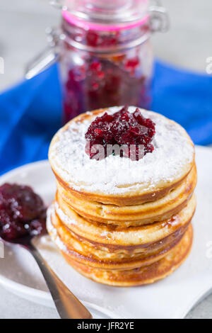 In casa frittelle americana servita con rosso marmellata di mirtilli sul tovagliolo blu, Americal bandiera colori, colazione in stile americano Foto Stock