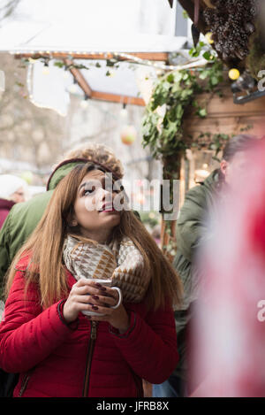 Giovane donna di bere vino caldo Foto Stock