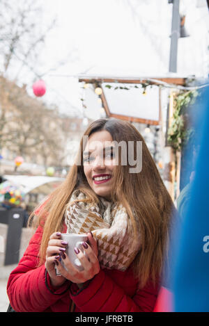 Ritratto di giovane donna di bere vino caldo Foto Stock