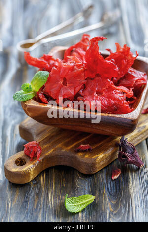 Ciotola di legno con secchi fiori di ibisco. Foto Stock