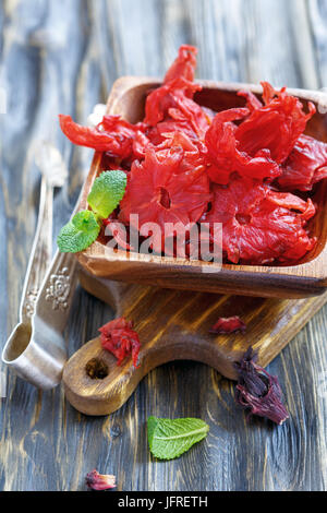 Essiccati fiori di ibisco in una ciotola di legno. Foto Stock