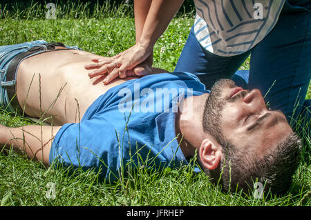 Ragazza rendendo rianimazione di un inconscio guy dopo un attacco di cuore Foto Stock