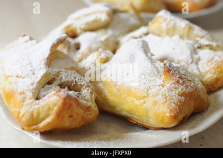 Bignè con marmellata di mele e zucchero in polvere su una piastra bianca close up Foto Stock