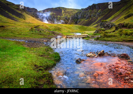 Piedi ponte sul Fiume Caldo nella valle di Reykjadalur nel sud dell'Islanda Foto Stock