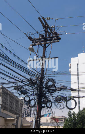 Un sacco di cavi elettrici dei pali della luce Foto Stock