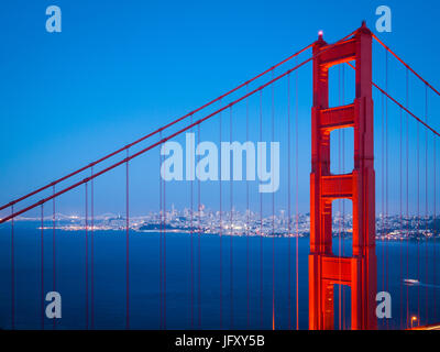 Una spettacolare vista del Golden Gate Bridge di notte, con la messa in scena del suo skyline di San Francisco in background Foto Stock