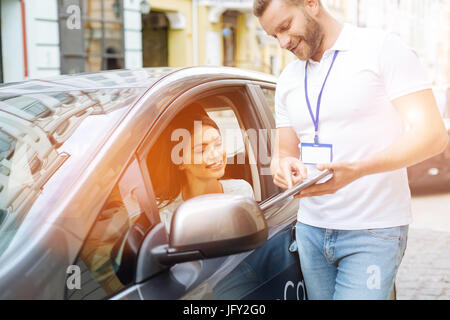 Dipendente di agenzia che mostra qualcosa su tablet a client Foto Stock