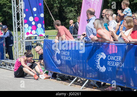 Southampton, Regno Unito. 02Luglio, 2017. Giovane atleta, che soffrono di esaurimento di calore, è di aiuto da parte degli astanti al traguardo della corsa per la vita. Questa gara annuale è gestito da donne per raccogliere fondi per la ricerca sul cancro. Credito: Jane Rix/Alamy Live News Foto Stock