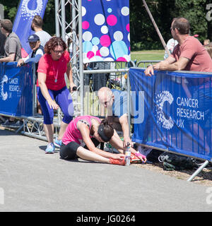 Southampton, Regno Unito. 02Luglio, 2017. Giovane atleta, che soffrono di esaurimento di calore, è di aiuto da parte degli astanti al traguardo della corsa per la vita. Questa gara annuale è gestito da donne per raccogliere fondi per la ricerca sul cancro. Credito: Jane Rix/Alamy Live News Foto Stock