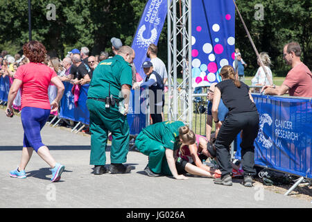 Southampton, Regno Unito. 02Luglio, 2017. Giovane atleta, che soffrono di esaurimento di calore, è di aiuto da parte di personale paramedico al traguardo della corsa per la vita. Questa gara annuale è gestito da donne per raccogliere fondi per la ricerca sul cancro. Credito: Jane Rix/Alamy Live News Foto Stock