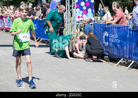 Southampton, Regno Unito. 02Luglio, 2017. Giovane atleta, che soffrono di esaurimento di calore, è di aiuto da parte di personale paramedico al traguardo della corsa per la vita. Questa gara annuale è gestito da donne per raccogliere fondi per la ricerca sul cancro. Credito: Jane Rix/Alamy Live News Foto Stock