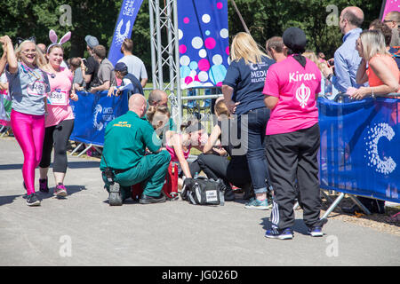 Southampton, Regno Unito. 02Luglio, 2017. Giovane atleta, che soffrono di esaurimento di calore, è di aiuto da parte di personale paramedico al traguardo della corsa per la vita. Questa gara annuale è gestito da donne per raccogliere fondi per la ricerca sul cancro. Credito: Jane Rix/Alamy Live News Foto Stock
