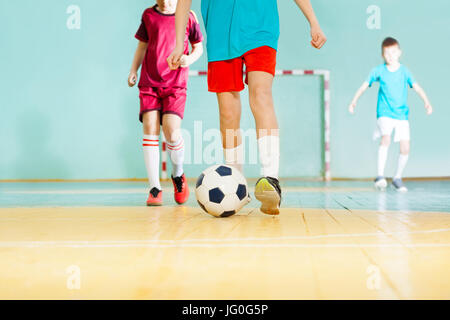 Close-up di giocatore di football per le gambe che colpisce la sfera durante il match in futsal Foto Stock