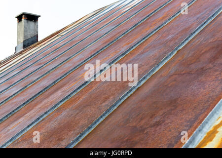 Vecchio di ferro arrugginito tetto metallico con camino Foto Stock