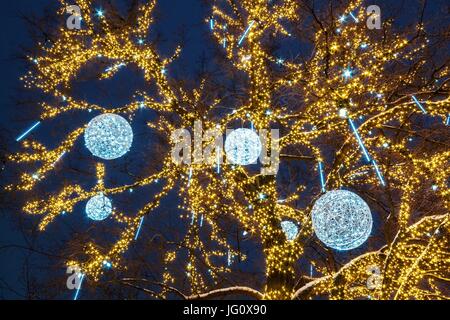 Anno nuovo albero decorato con sfere con illuminazione illuminata di sera nel parco della città Dnipropetrovsk, Ucraina Foto Stock