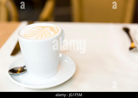 Tazza di caffè caldo, latte sul tavolo al ristorante Foto Stock