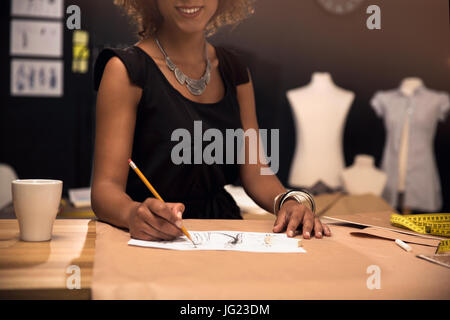 Ritratto di una giovane designer di moda lavorando sul suo atelier Foto Stock