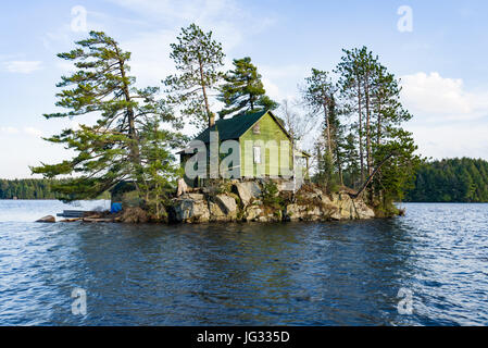 Casa in legno sulla piccola isola circondata da alberi e il lago, Algonquin Provincial Park, Ontario, Canada Foto Stock